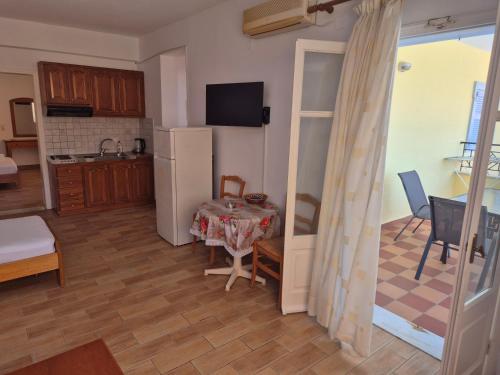a kitchen and dining room with a table and a refrigerator at Eptanisa Hotel in Mikros Gialos