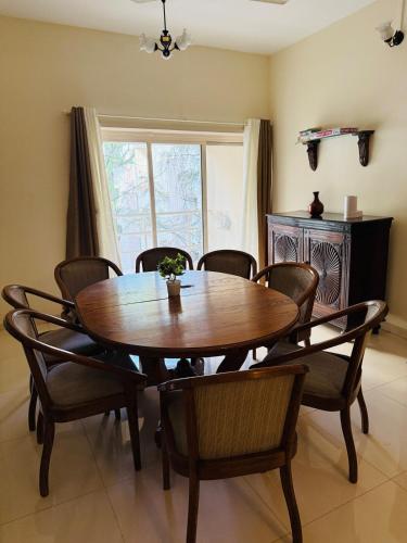 a dining room with a wooden table and chairs at Sukh Spacious 2BHK in KP Private 4 Balconies in Pune