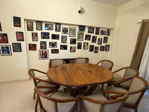 a dining room table and chairs with pictures on the wall at Sukh Spacious 2BHK in KP Private 4 Balconies in Pune