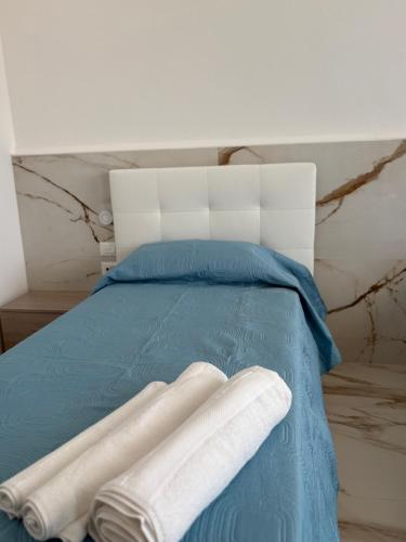 a blue bed with two white towels on it at Albergo Santa Croce in Giffoni Sei Casali