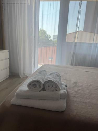 1 dormitorio con toallas en una cama con ventana en Angelica Home, en Bucarest