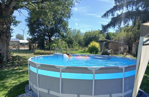 a woman is in a hot tub in a yard at Studio indépendant T1, entre Nantes et Rennes in Conquereuil