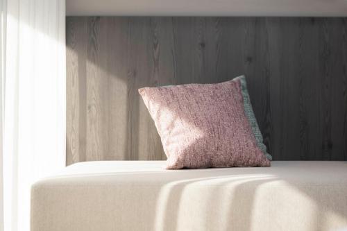 a pink pillow sitting on top of a bed at Neueröffnung ELVA PREMIUM APARTMENT HOTEL inklusive Sommerpass STUBAI SUPER CARD in Neustift im Stubaital