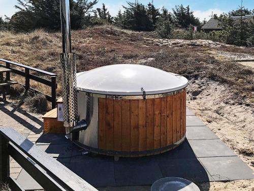 a wooden drum sitting next to a bench at Luxury Pool Retreat by Sea - By Traum Ferienwohnungen in Harboør