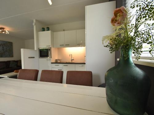 a green vase sitting on a table in a kitchen at Wellness aan het Water in Earnewoude in Earnewâld