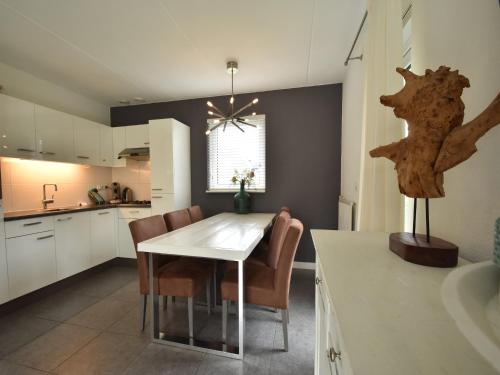 a kitchen and dining room with a white table and chairs at Wellness aan het Water in Earnewoude in Earnewâld