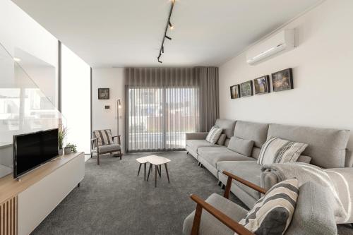 a living room with a couch and a tv at Lua Tranquilizante in Foz do Arelho