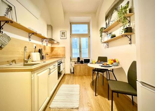 a kitchen with a small table and a kitchen with white cabinets at Elegant apartment in Kosice in Košice