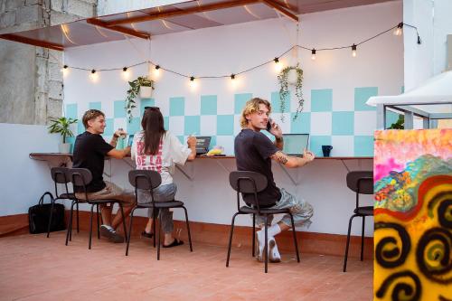a group of people sitting at a bar at Doña Rose Surf Hostel in Las Palmas de Gran Canaria