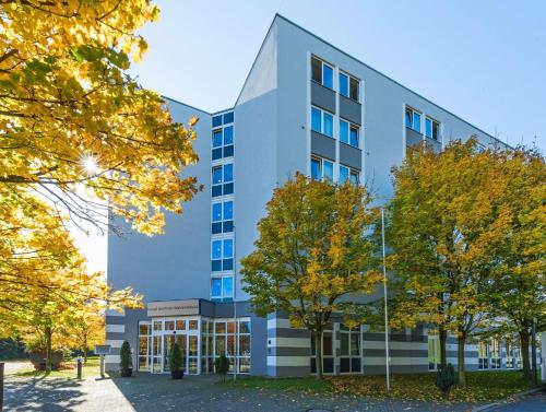an office building with trees in front of it at Hotel Bochum Wattenscheid affiliated by Meliá in Bochum