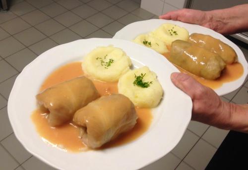 a person holding a plate of food on a plate at Willa Hamernik AGROTURYSTYKA in Tylicz