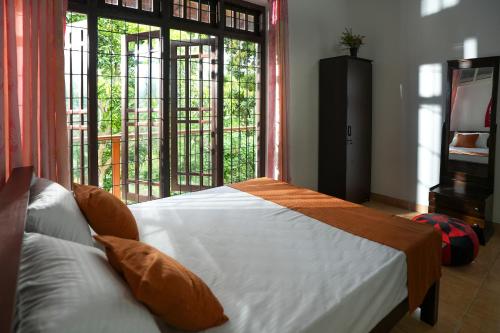 um quarto com uma cama e uma janela grande em V&C Hideout Villa & Hostel em Kandy