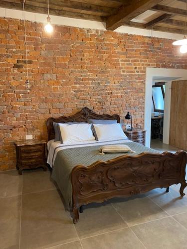 una camera con letto in legno su un muro di mattoni di Agriturismo AgriTexS a Savigliano