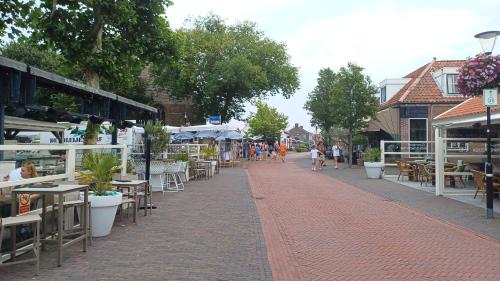 a street with tables and chairs and people walking down the street at Camino in Vrouwenpolder