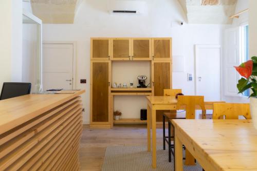 una cucina e una sala da pranzo con tavoli e sedie in legno di T rooms a Lecce