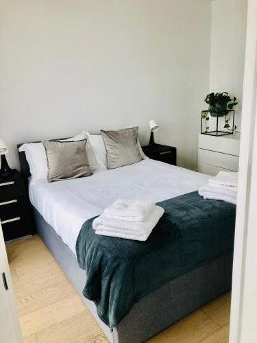 a bedroom with a large bed with towels on it at 1 bedroom luxury apartment 20 min from centre in London