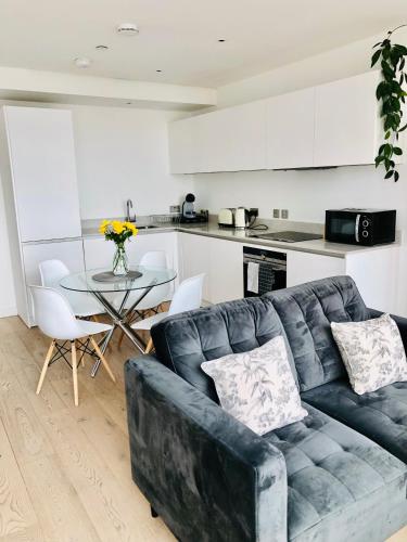 a living room with a couch and a table in a kitchen at 1 bedroom luxury apartment 20 min from centre in London