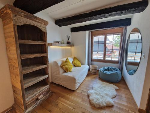 a living room with a couch and a large window at Chalet typique proche Crans Montana in Icogne