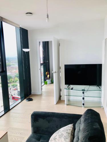 a living room with a couch and a flat screen tv at 1 bedroom luxury apartment 20 min from centre in London