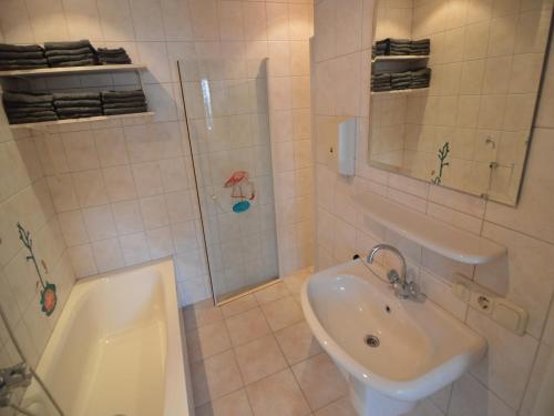 a white bathroom with a sink and a shower at Farmhouse in Haarlo near Lake Hambroek in Haarlo