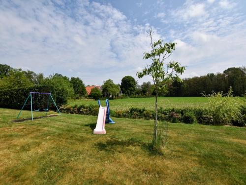 a park with two playground equipment in a field at Farmhouse in Haarlo near Lake Hambroek in Haarlo