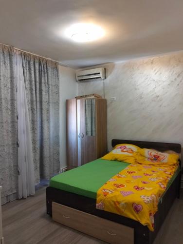 a bedroom with a bed with a yellow blanket at Apartament BIS in Buzau