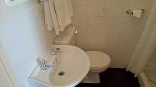 a bathroom with a toilet and a sink at The Belgrave Hotel Tenby in Tenby