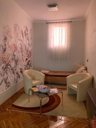 a living room with a bed and a table and chairs at Szent István Apartman in Makó
