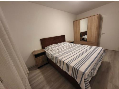 a bedroom with a bed and a wooden cabinet at Lili's Cozy Apartment in Pristina