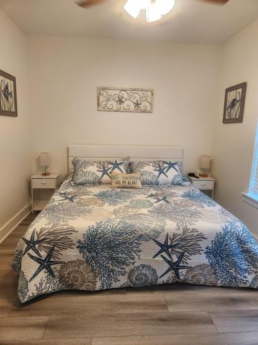 a bedroom with a bed with a comforter on it at Bluebird By The Sea in Gulfport