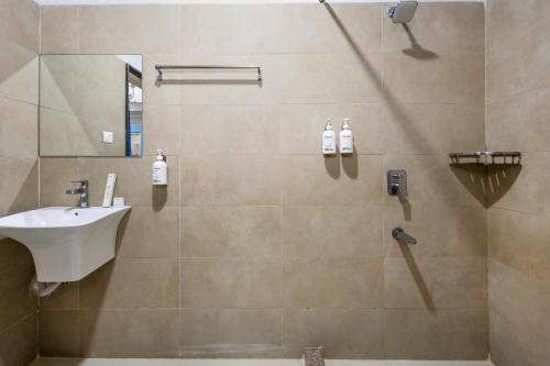une salle de bain avec une douche avec un lavabo et un miroir dans l'établissement Kove Stays, à Hyderabad