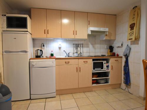 Una cocina con gabinetes de madera y un refrigerador blanco. en Villa in Saint-Cyprien with Sea View, en Latour-Bas-Elne