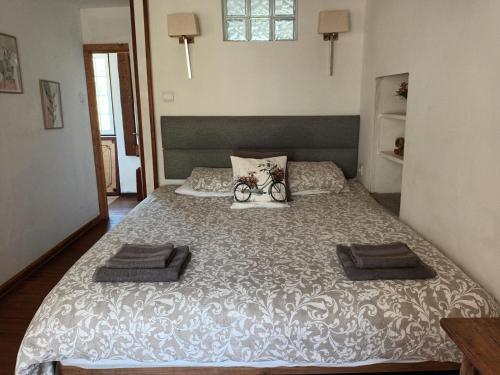 a bedroom with a large bed with two towels on it at A Casa da Bicicleta in Lousã