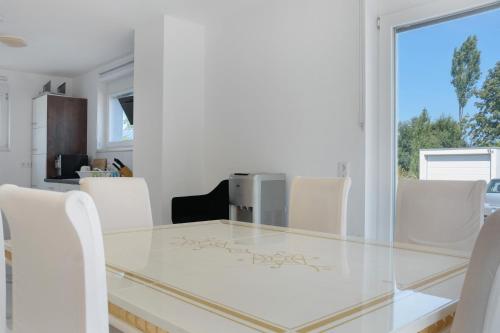 a dining room with a glass table and white chairs at Luxusvilla Neubau 1 in Oberasbach