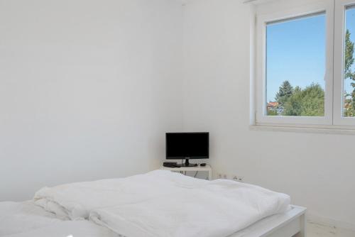 a white bedroom with a bed and a window at Luxusvilla Neubau 1 in Oberasbach