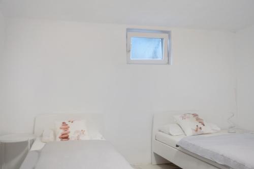 a white bedroom with a bed and a window at Luxusvilla Neubau 1 in Oberasbach