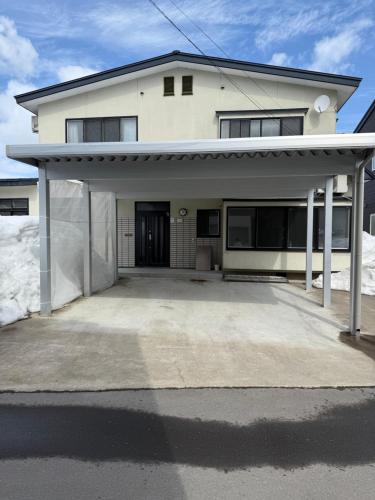 a large white house with a large driveway at 自然体験と石窯のある古民家民泊アジールAsyl in Hirosaki