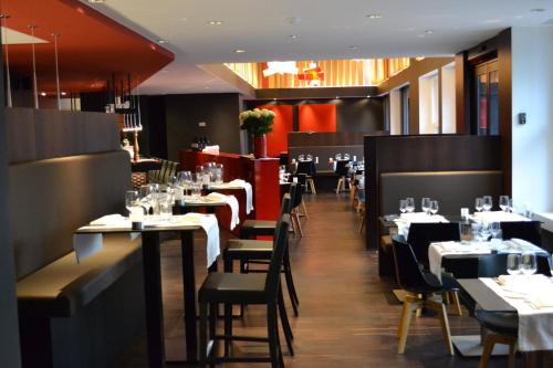 a dining room with tables and chairs in a restaurant at Crowne Plaza Hotel Brugge by IHG in Bruges
