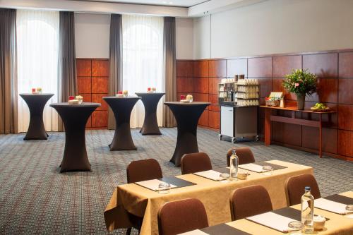 a conference room with tables and chairs and a podium at Crowne Plaza Hotel Brugge by IHG in Bruges