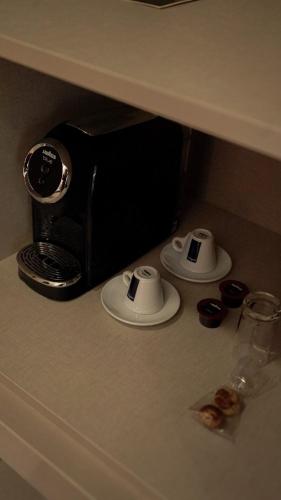 a counter with a coffee maker and cups on it at VISEU EXECUTIVE Hotel in Viseu