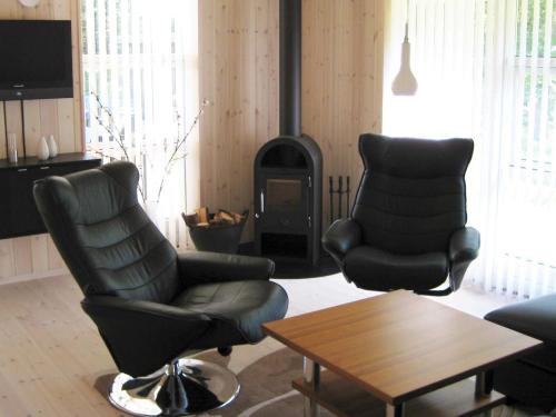 a living room with two chairs and a stove at 6 person holiday home in Silkeborg-By Traum in Engesvang