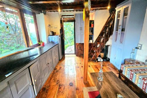 a living room with a wooden floor and a staircase at Parvatis Lap Luxury Hostel & Camps in Kasol