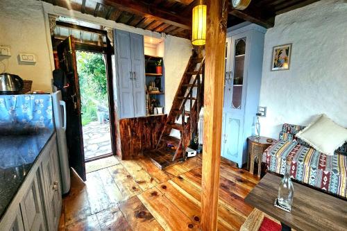 a living room with a wooden floor and a ladder at Parvatis Lap Luxury Hostel & Camps in Kasol