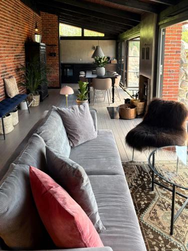 a living room with a gray couch with pillows at Nordic Holiday Home With Fjord Views On Enø in Karrebæksminde