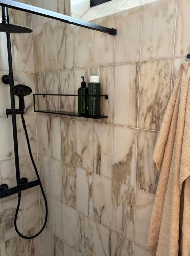 a bathroom with a shower with marble tiles at Nordic Holiday Home With Fjord Views On Enø in Karrebæksminde
