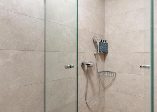 ducha con puerta de cristal y cabezal de ducha en Metis by Vintage Travel, en Vasilikos