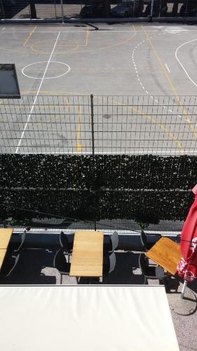 a tennis court with two wooden benches and a net at Arco Arina Apartment in Pula
