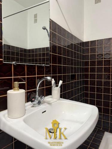 a bathroom sink with a mirror and a house sign on it at Le Cloître Jardin privatif, Ligny-en-barrois in Ligny-en-Barrois