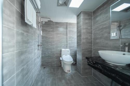 a bathroom with a white toilet and a sink at 梦境酒店壹号客栈 in Zhangjiajie