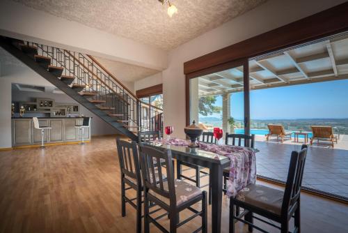 a dining room with a table and chairs and a staircase at Castelli by Vintage Travel in Lagópodhon